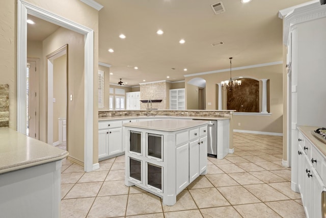 kitchen with light countertops, a kitchen island, visible vents, and white cabinets