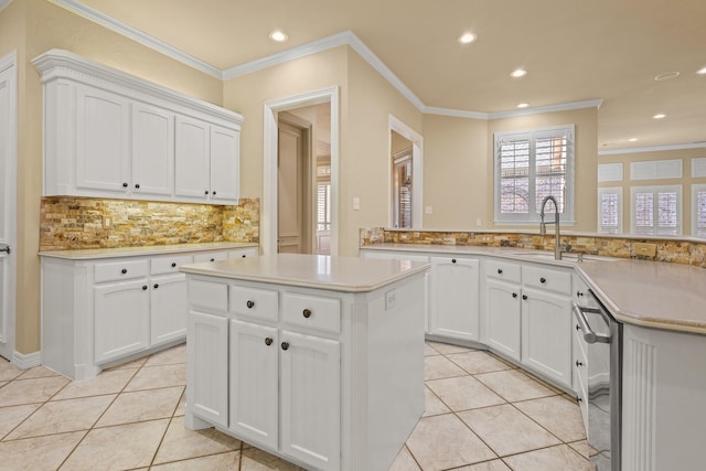 kitchen featuring a peninsula, light countertops, white cabinetry, and a center island