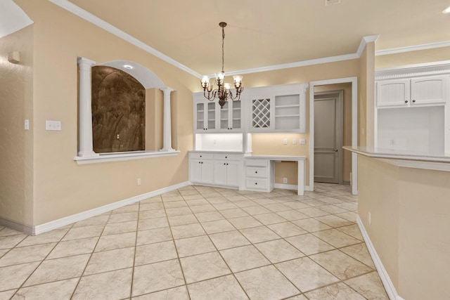 unfurnished dining area featuring ornamental molding, light tile patterned flooring, an inviting chandelier, and baseboards