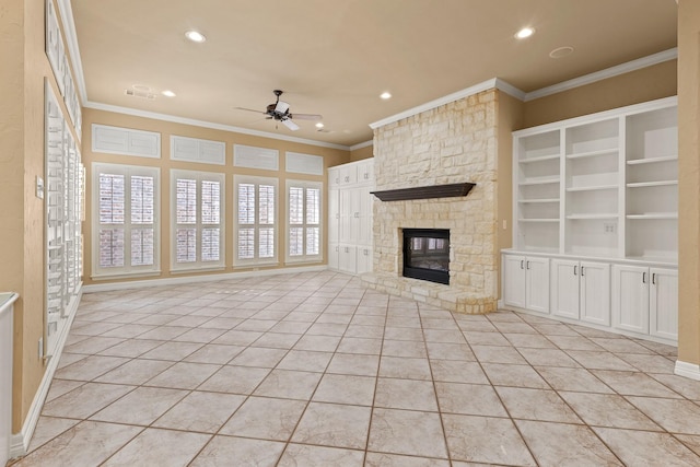 unfurnished living room featuring light tile patterned floors, visible vents, ceiling fan, ornamental molding, and a stone fireplace