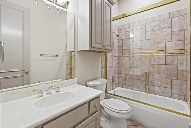 full bath featuring combined bath / shower with glass door, vanity, and toilet