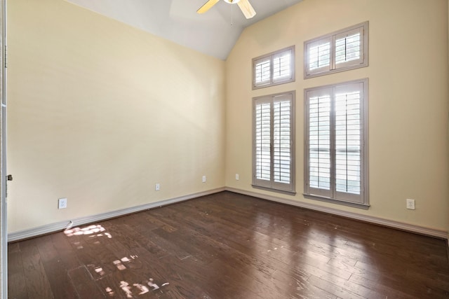 empty room featuring ceiling fan, baseboards, vaulted ceiling, and dark wood-type flooring