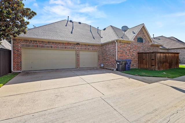 view of front of property featuring brick siding, driveway, an attached garage, and roof with shingles