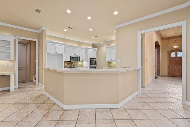 kitchen with arched walkways, stainless steel appliances, visible vents, white cabinetry, and light countertops