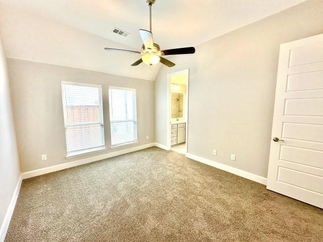 unfurnished room featuring baseboards, visible vents, lofted ceiling, ceiling fan, and carpet flooring