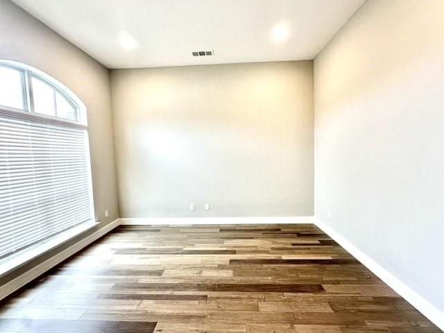 unfurnished room with baseboards and wood finished floors