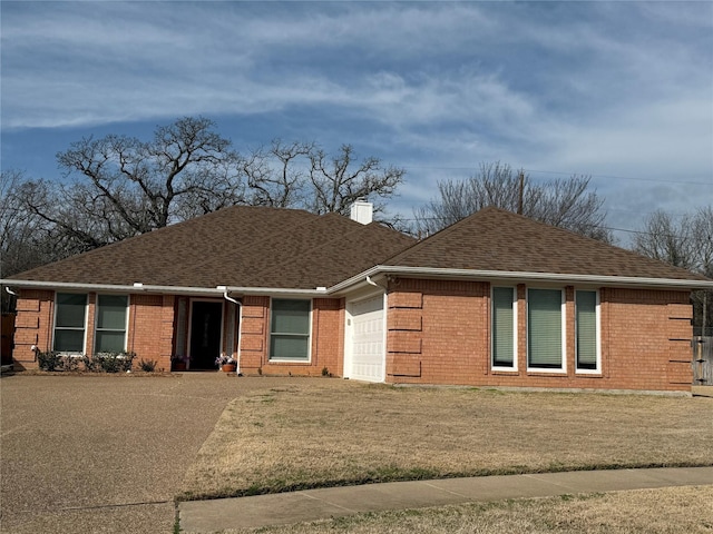 view of front of house with a shingled roof, a chimney, an attached garage, and brick siding