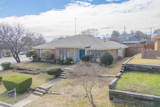 1001 British Blvd, Grand Prairie, TX 75050 - ranch-style house featuring brick siding, a shingled roof, a front yard, and fence