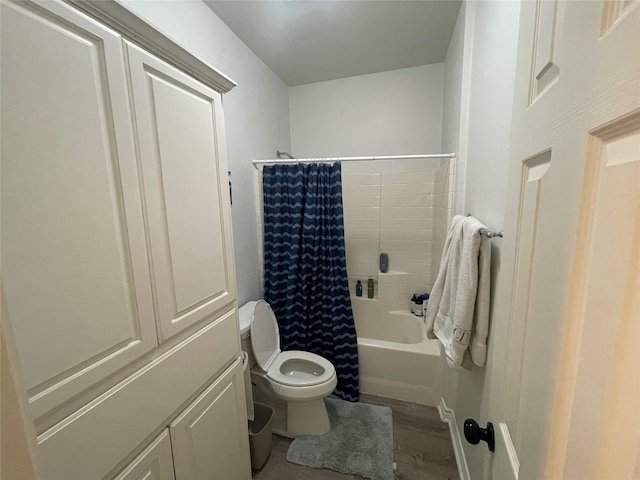 bathroom with wood finished floors, shower / bath combination with curtain, and toilet