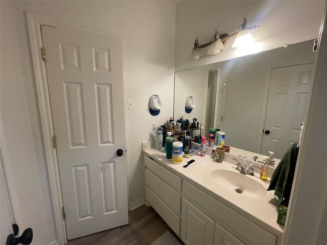 bathroom with wood finished floors and vanity