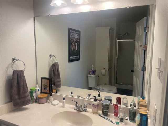 full bathroom featuring a stall shower, vanity, and toilet