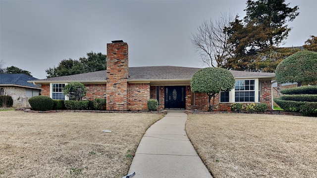 ranch-style house featuring brick siding and a front lawn