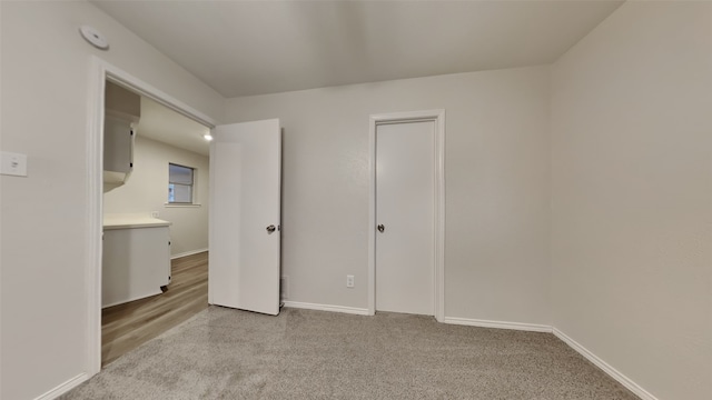 unfurnished bedroom featuring light colored carpet and baseboards