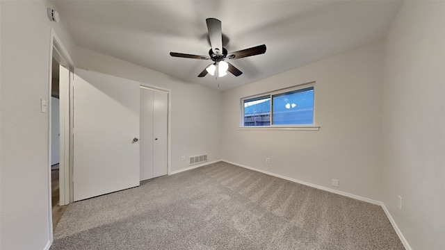 unfurnished bedroom with a closet, light colored carpet, visible vents, a ceiling fan, and baseboards