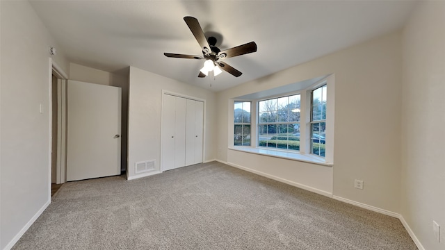 unfurnished bedroom with a closet, carpet, visible vents, and baseboards