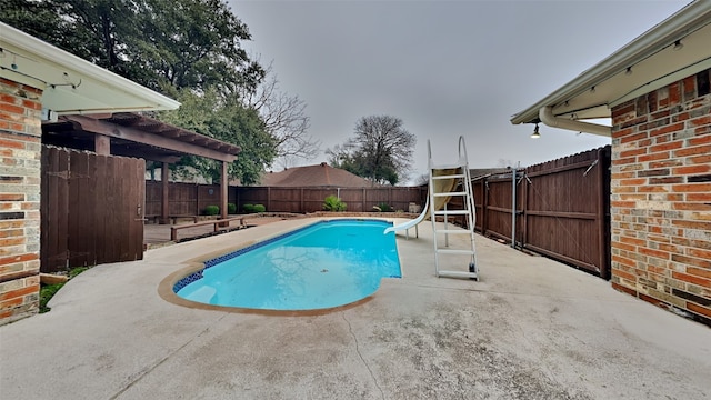 view of swimming pool with a fenced in pool, a patio area, a water slide, and a fenced backyard