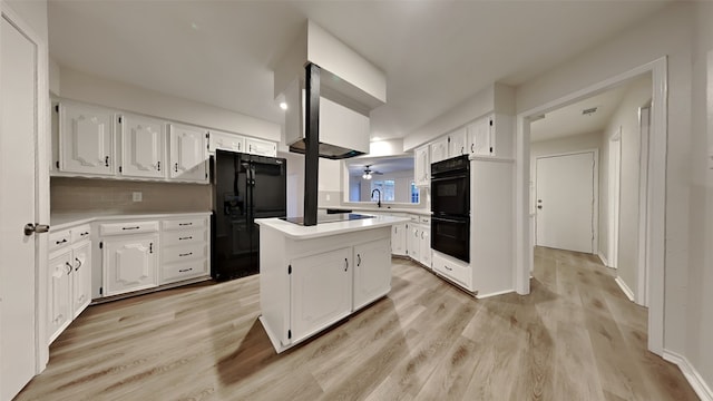 kitchen with a center island, light countertops, light wood-style floors, white cabinetry, and black appliances