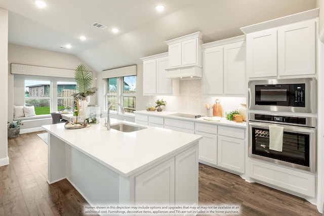 kitchen featuring visible vents, oven, built in microwave, light countertops, and a sink