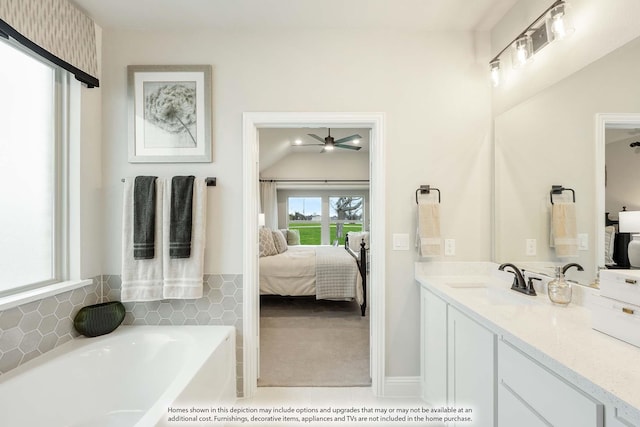 bathroom featuring ensuite bath, a bath, and vanity