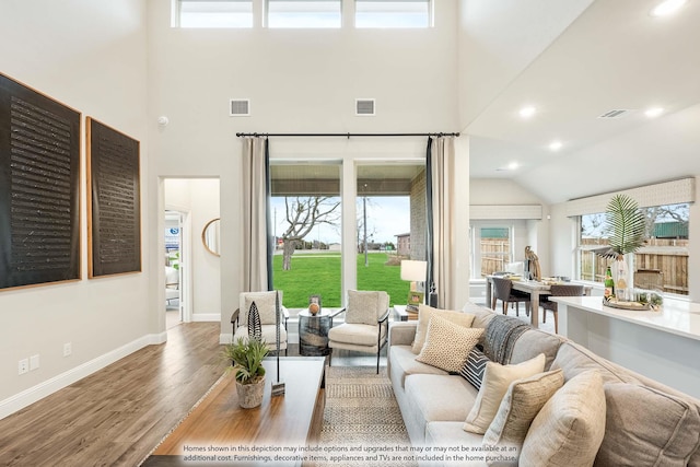 living area featuring wood finished floors, visible vents, and baseboards