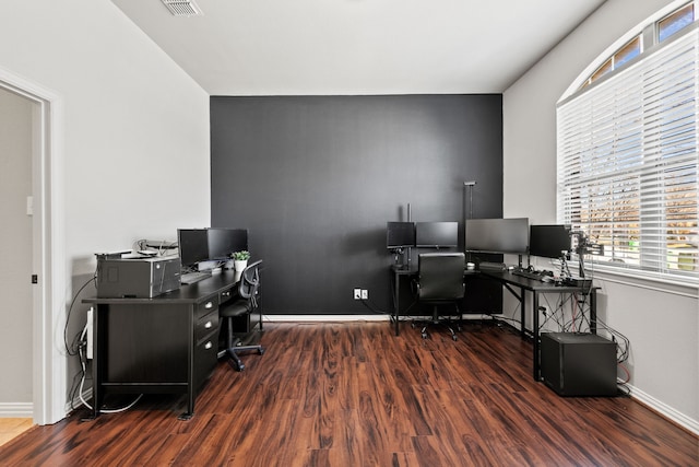 home office featuring dark wood-style flooring, visible vents, and baseboards