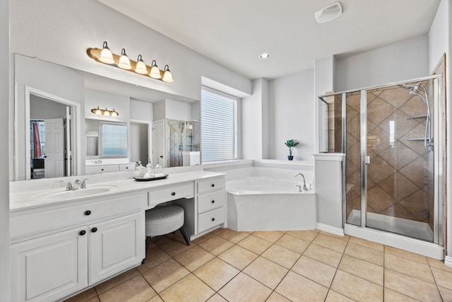 bathroom with a stall shower, tile patterned flooring, a garden tub, and vanity