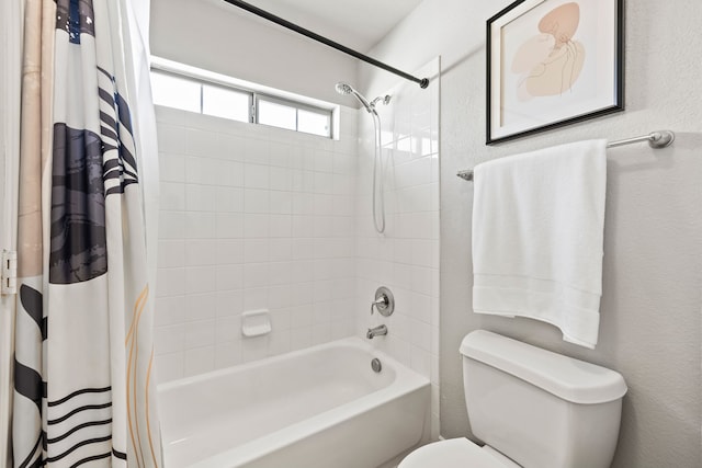 full bath with toilet, shower / bath combo with shower curtain, and a textured wall