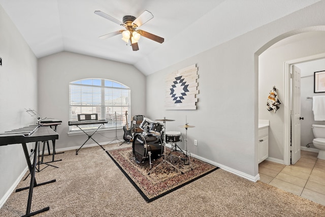 game room featuring light carpet, vaulted ceiling, light tile patterned flooring, and arched walkways