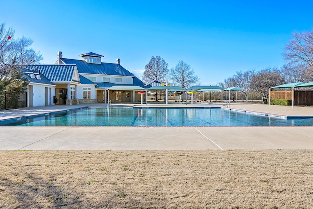 community pool with a patio area and fence