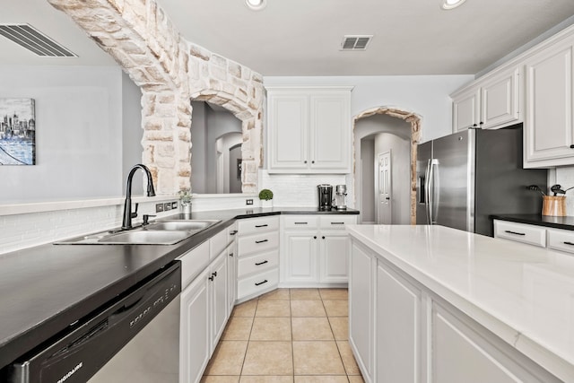 kitchen featuring appliances with stainless steel finishes, a sink, visible vents, and white cabinetry