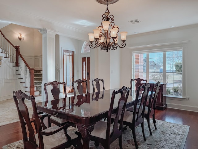 dining room featuring a notable chandelier, crown molding, wood finished floors, and visible vents