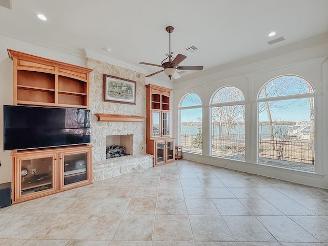 unfurnished living room featuring visible vents, a water view, crown molding, a stone fireplace, and recessed lighting