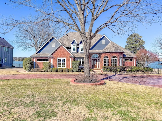 view of front facade with brick siding and a front yard