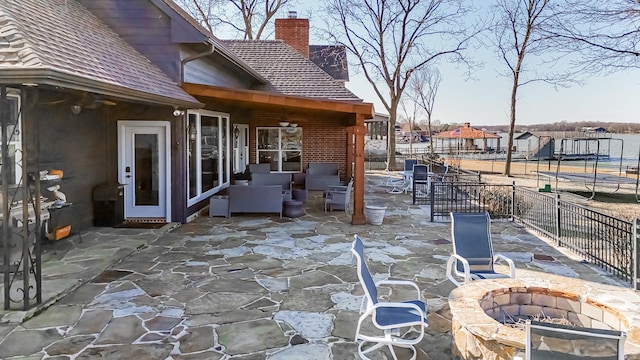 view of patio featuring an outdoor fire pit and fence