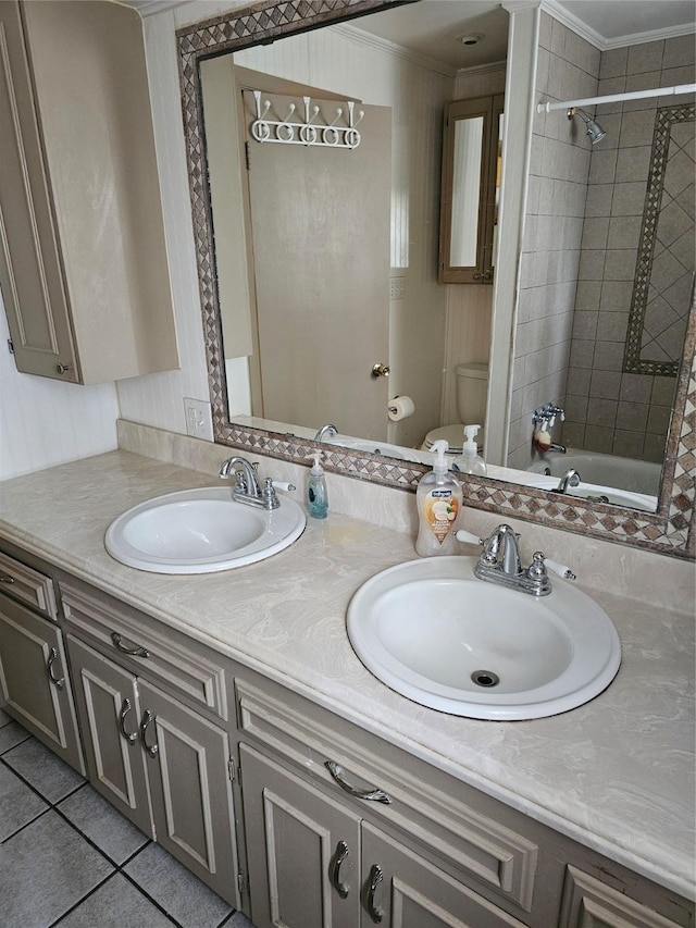 bathroom featuring crown molding, a sink, toilet, and tile patterned floors