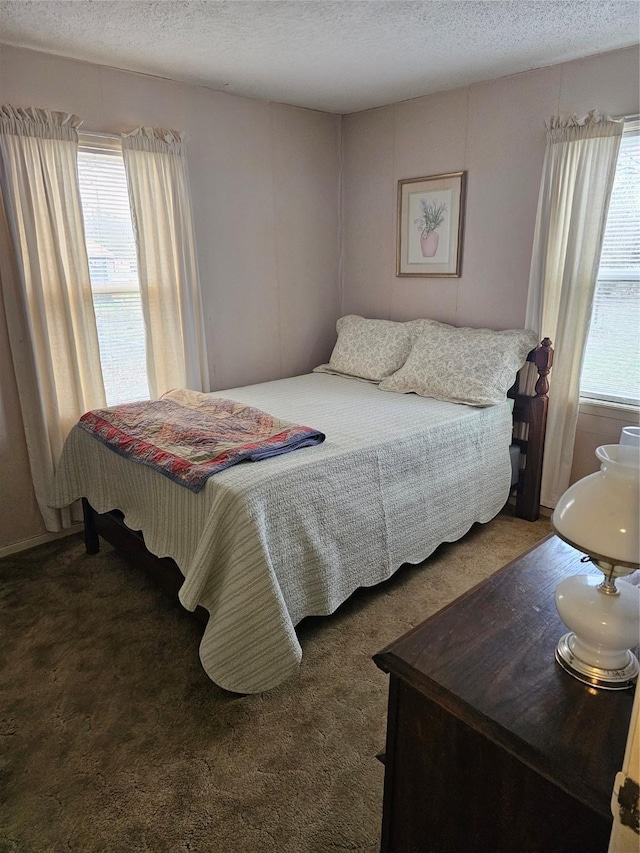 carpeted bedroom featuring multiple windows and a textured ceiling