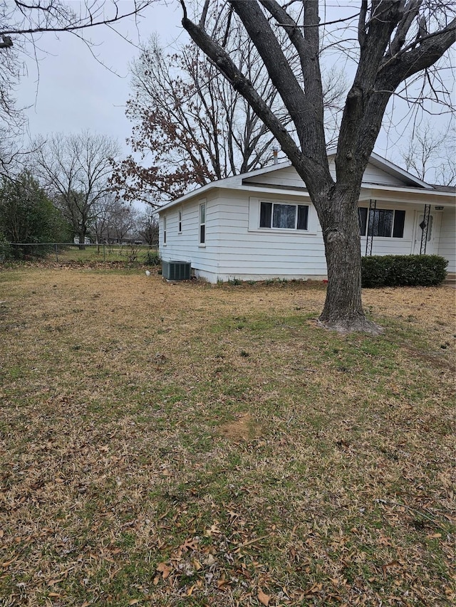 view of side of property featuring a yard and cooling unit