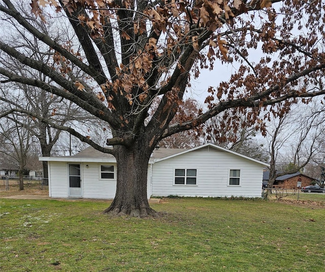 view of side of home with a yard and fence