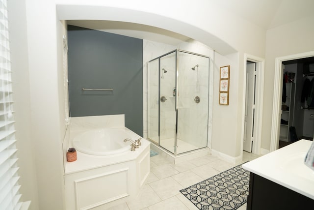 bathroom with tile patterned floors, a garden tub, a walk in closet, vanity, and a shower stall