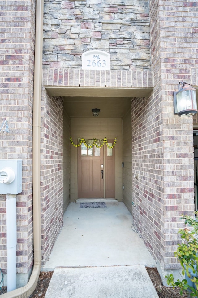 entrance to property featuring brick siding