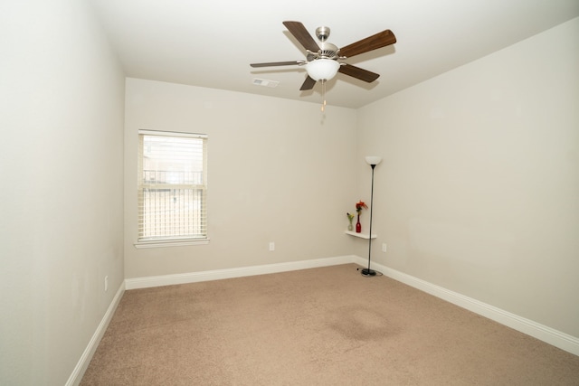 carpeted empty room with baseboards, visible vents, and ceiling fan