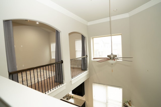 hallway with a towering ceiling, stairs, and ornamental molding