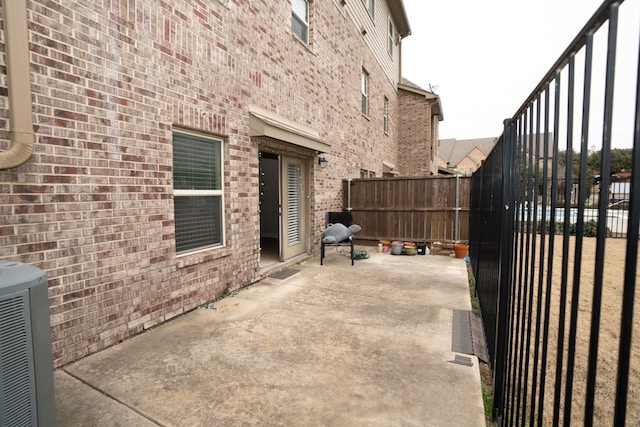 view of patio featuring central air condition unit and fence