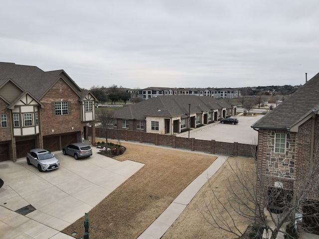 exterior space with a garage, a residential view, and driveway