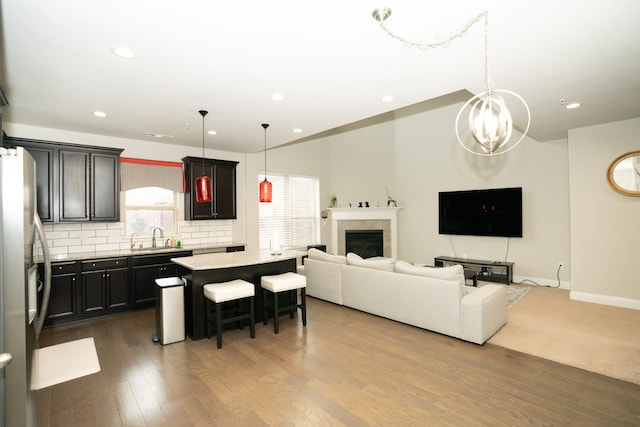 living room with a fireplace, baseboards, wood finished floors, and recessed lighting