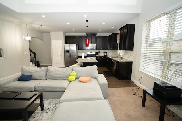 living room with stairs, recessed lighting, arched walkways, and baseboards