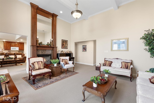 carpeted living room featuring baseboards, a towering ceiling, and a lit fireplace