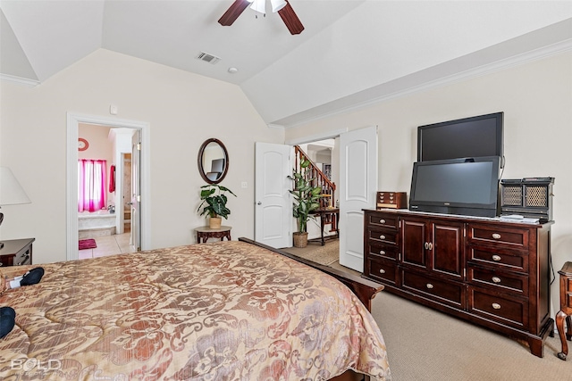 bedroom featuring visible vents, lofted ceiling, carpet floors, and ensuite bath