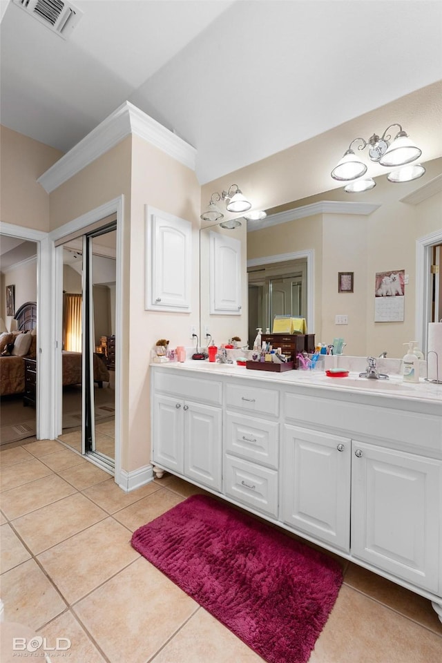 full bath with visible vents, crown molding, double vanity, tile patterned floors, and ensuite bath