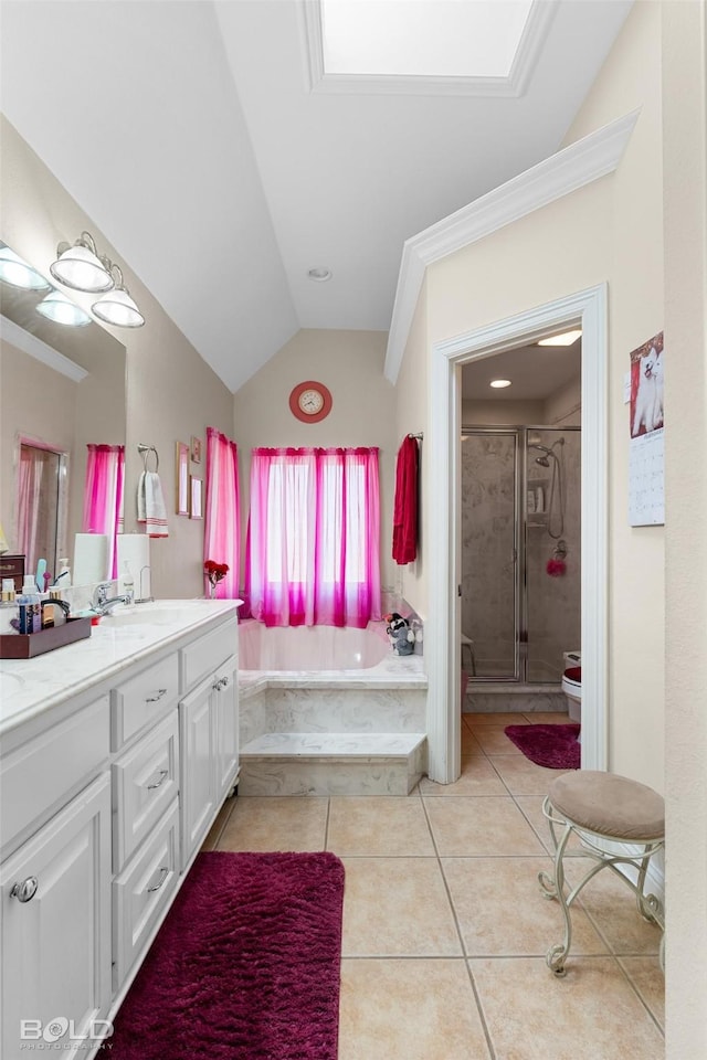 bathroom with double vanity, a stall shower, tile patterned flooring, vaulted ceiling, and a garden tub